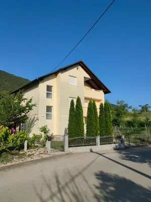 a white house with a fence and trees at Apartman Bošnjak Ramsko jezero in Podbor