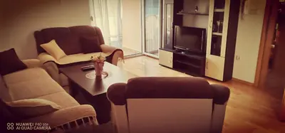 a living room with a table and chairs and a tv at Apartman Bošnjak Ramsko jezero in Podbor