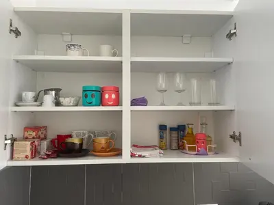 a white cabinet filled with dishes and glasses at Studio Apartman Centar in Zenica