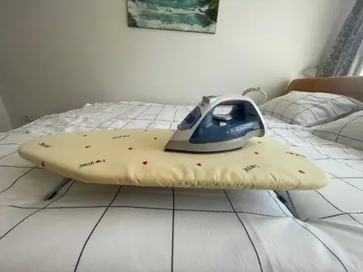 a iron is sitting on top of a bed at Studio Apartman Centar in Zenica
