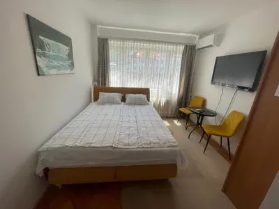 a bedroom with a bed and a flat screen tv at Studio Apartman Centar in Zenica