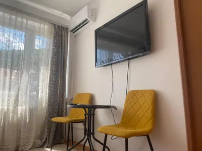 a room with two chairs and a flat screen tv on the wall at Studio Apartman Centar in Zenica