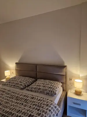 a bedroom with a bed with two night stands and two lamps at Nika in Banja Luka