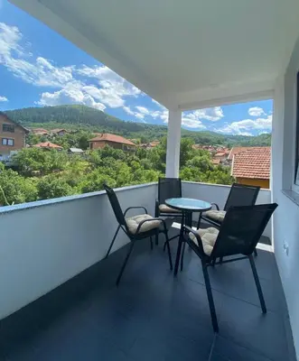 a balcony with four chairs and a table and a view at Sunset Delux Apartment in Visoko