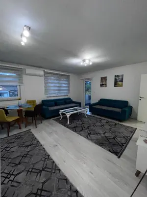 a living room with two blue couches and a table at Sunset Delux Apartment in Visoko