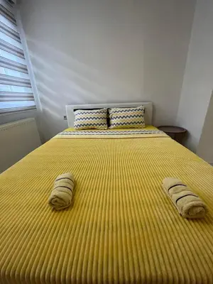 a large yellow bed with two pillows on it at Sunset Delux Apartment in Visoko