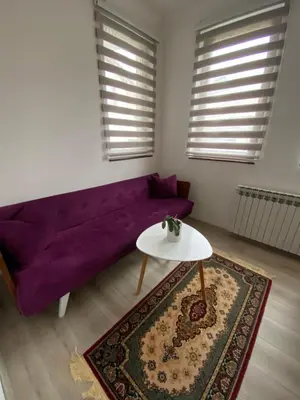 a living room with a purple couch and a table at Royal Residence in Visoko