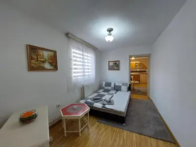 a living room with a bed and a table at Apartment EM in Tuzla