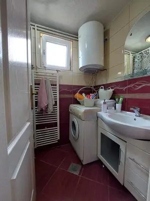 a bathroom with a sink and a washing machine at Apartment EM in Tuzla