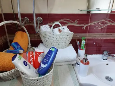 a bathroom with two baskets of toothbrushes and a sink at Apartment EM in Tuzla
