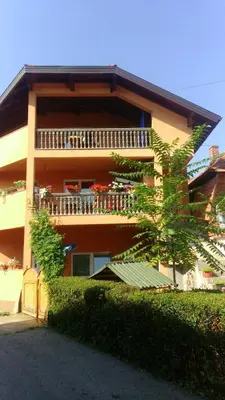 a building with a balcony with flowers on it at Apartment EM in Tuzla