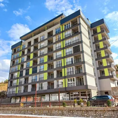 an apartment building with yellow and gray at Apartment Aria in Travnik
