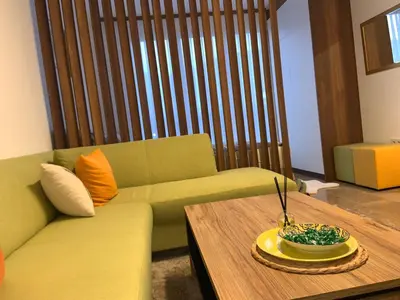 a living room with a green couch and a table at Apartment Aria in Travnik