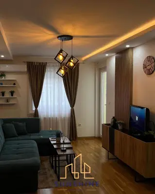 a living room with a green couch and a tv at Apartman Sunshine in Doboj