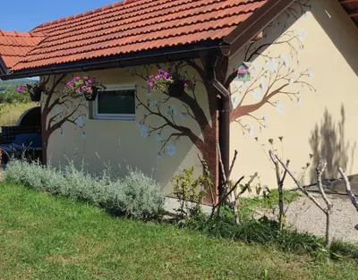 a small house with a red roof with flowers on it at Riverside Plaza in Bihać