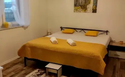 a bedroom with a bed with yellow sheets and yellow pillows at Riverside Plaza in Bihać