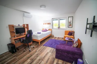 a small living room with a bed and a desk at Riverside Plaza in Bihać