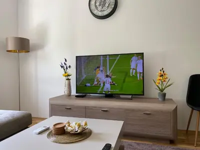 a living room with a flat screen tv on a wooden entertainment center at New Apartment in the City in Visoko