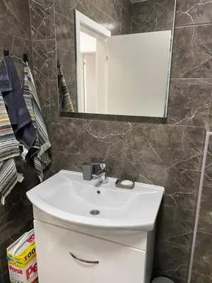 a bathroom with a white sink and a mirror at New Apartment in the City in Visoko