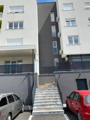 two cars parked in a parking lot in front of a building at New Apartment in the City in Visoko