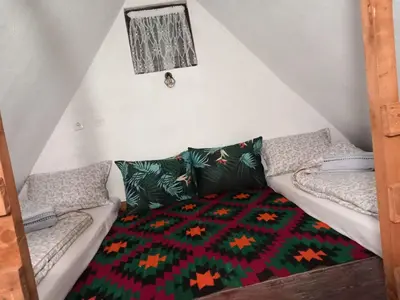 a room with a couch with a colorful blanket at Etno selo Visoko Apartmani in Visoko