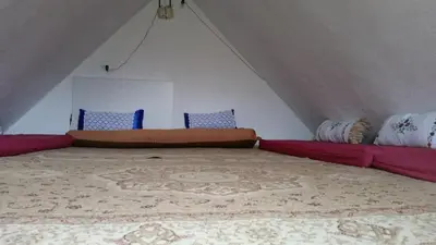 a attic room with a bed and a couch at Etno selo Visoko Apartmani in Visoko