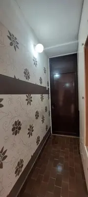 a hallway with a door and flowers on the wall at Apartman Centar Banja Luka in Banja Luka