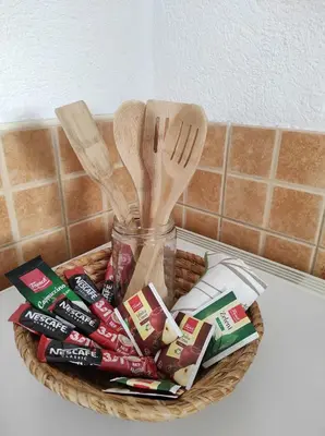 a basket with utensils and a jar of food at Apartman 
