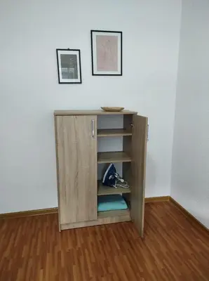 a wooden cupboard with a shelf in a room at Apartman 