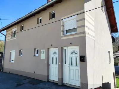a building with two white doors on it at Apartman 