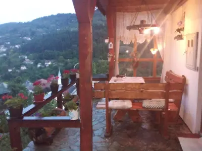 a room with a table and a balcony with a view at Privatni smještaj Kurtalija in Jajce