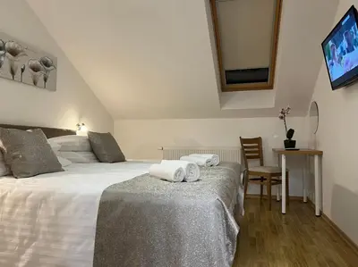 a bedroom with two beds and a table and a mirror at Penthouse City Center in Bihać