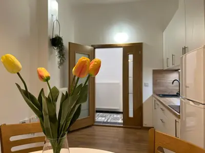 a vase of flowers sitting on a table in a kitchen at Penthouse City Center in Bihać