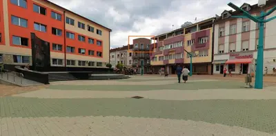 a group of buildings with people walking in a street at Penthouse City Center in Bihać