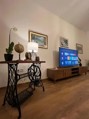 a living room with a television and a table with a lamp at Penthouse City Center in Bihać
