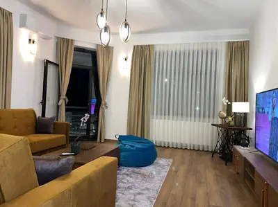 a living room with a couch and a tv at Penthouse City Center in Bihać