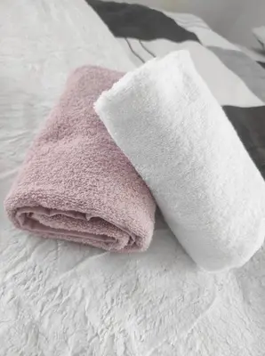 a pink towel sitting on top of a bed at Prenoćište Ljiljana 2 in Livno