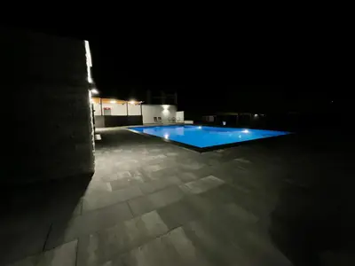 a swimming pool lit up at night at Holiday Houses Green Queen in Bihać