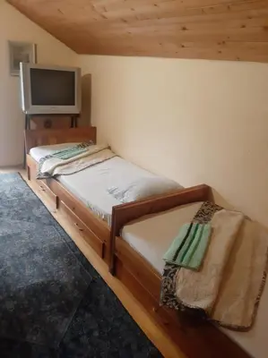 a small bedroom with a bed and a television at Relax house in Visoko