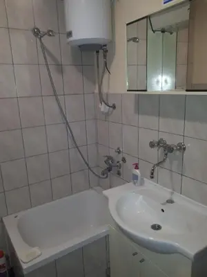 a bathroom with a sink and a tub and a mirror at Relax house in Visoko
