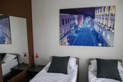 a room with two beds and a picture on the wall at Happy Hill Rooms in Banja Luka