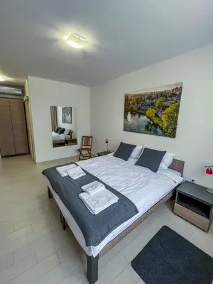 a bedroom with a large bed with towels on it at Happy Hill Rooms in Banja Luka
