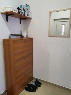 a bedroom with a dresser and a mirror and shoes at Studio Apartman 11 in Bihać