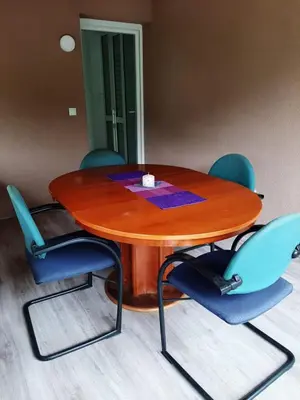 a wooden table with blue chairs around it at Apartman Dujmović in Visoko