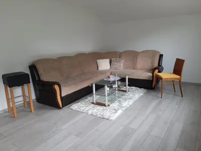 a living room with a brown couch and a table at Apartman Dujmović in Visoko