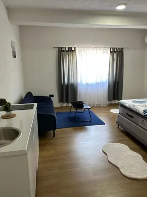 a living room with a blue couch and a sink at Apartmani Art in Jajce
