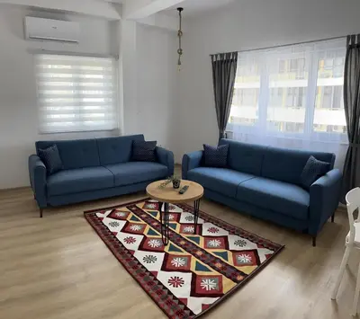 a living room with two blue couches and a table at Apartmani Art in Jajce