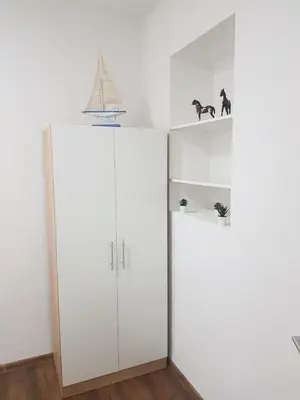 a white cabinet in a room with a white wall at Apartmani Art in Jajce