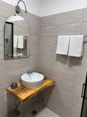 a bathroom with a sink and a mirror and towels at Ravne Energy Apartments in Visoko