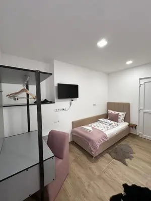 a bedroom with a bed and a tv on the wall at Ravne Energy Apartments in Visoko